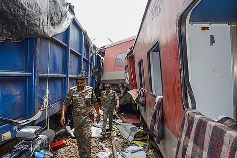 Security personnel inspect the area after train derailed near Badabamboo